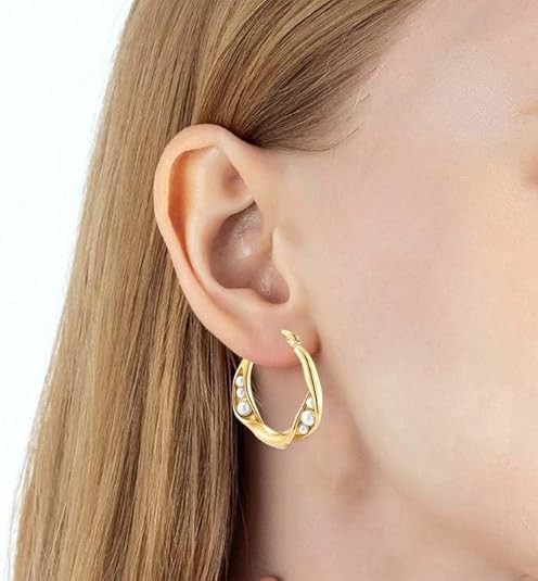 Gold hoop earrings with pearl detailing worn on ear, offering timeless elegance and refined sophistication for daily style.