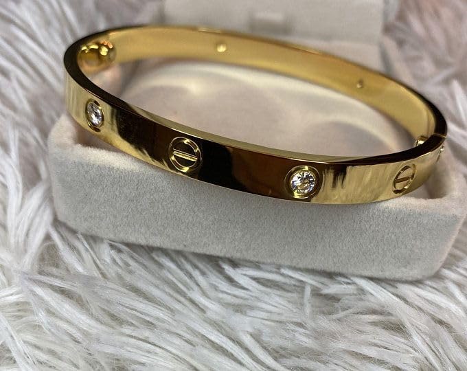 Gold bracelet with diamonds on a white stand against a white fur background