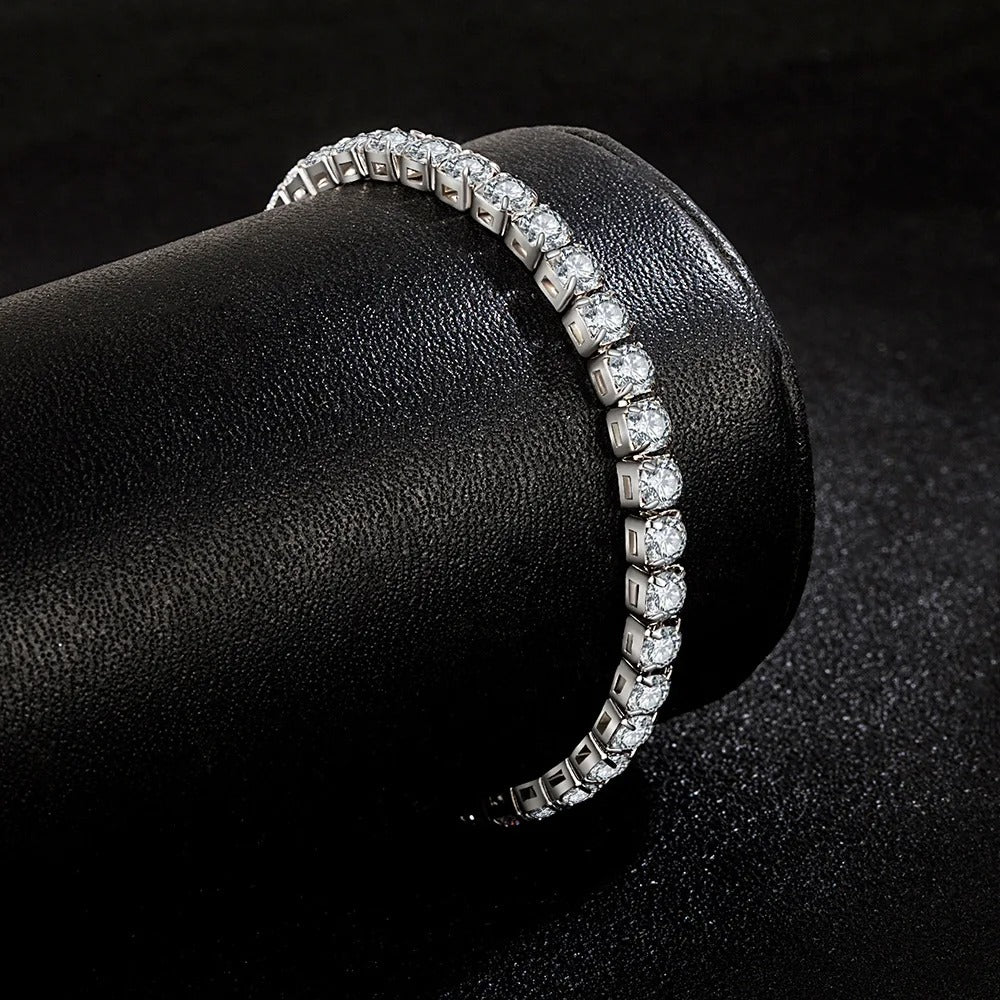 Elegant silver tennis bracelet with sparkling round stones displayed on a black leather roll.
