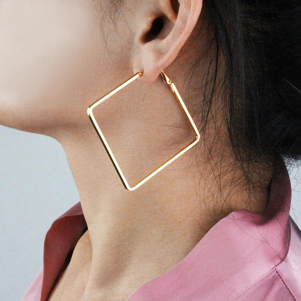 Trendy gold square hoop earrings worn on ear, minimal and modern jewelry style for elegant everyday look.