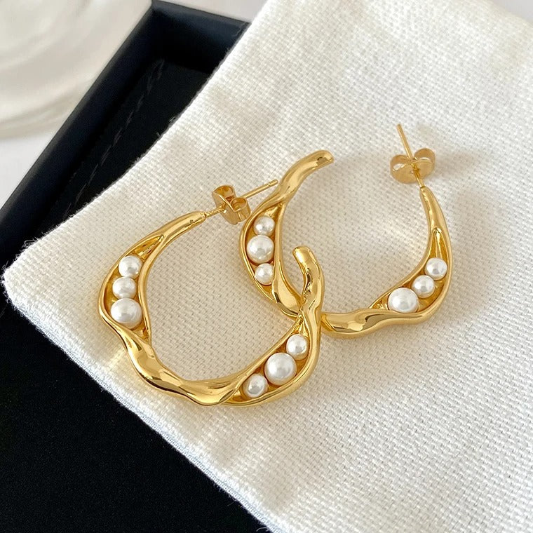 Elegant gold pearl stud earrings with artistic hoop design, crafted for modern women seeking luxury and sophistication