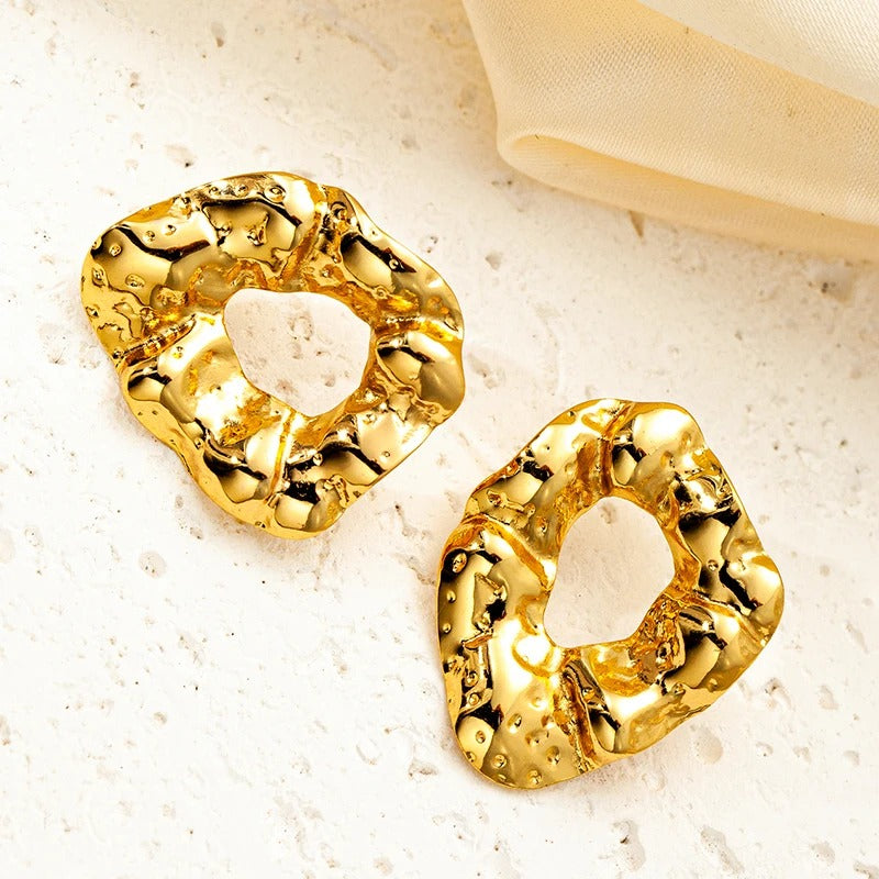 Chunky hammered gold earrings with irregular cut-out design, bold statement studs for chic and modern fashion looks.
