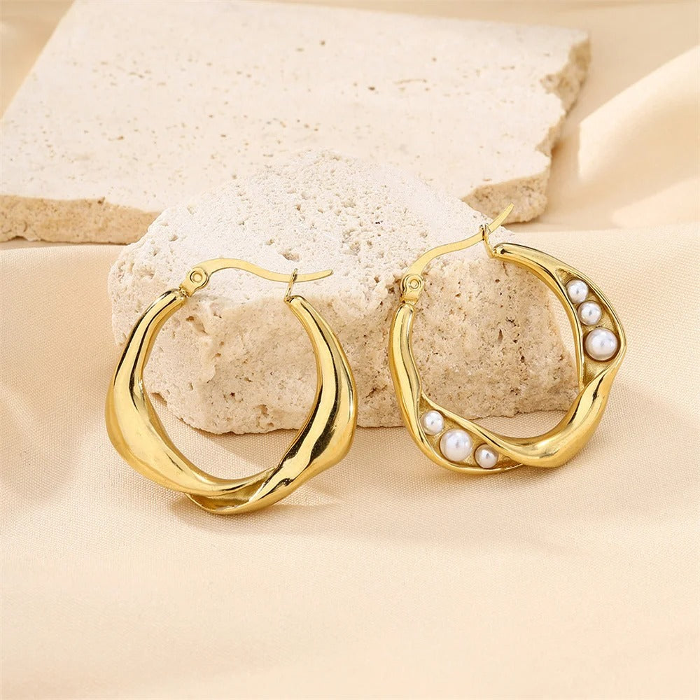 Stylish gold hoop earrings with pearl accents, designed to add timeless elegance and charm to any modern outfit.