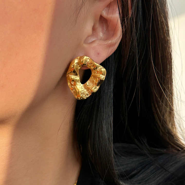Bold gold statement earrings with hammered texture, modern geometric stud design for elegant and trendy everyday style.
