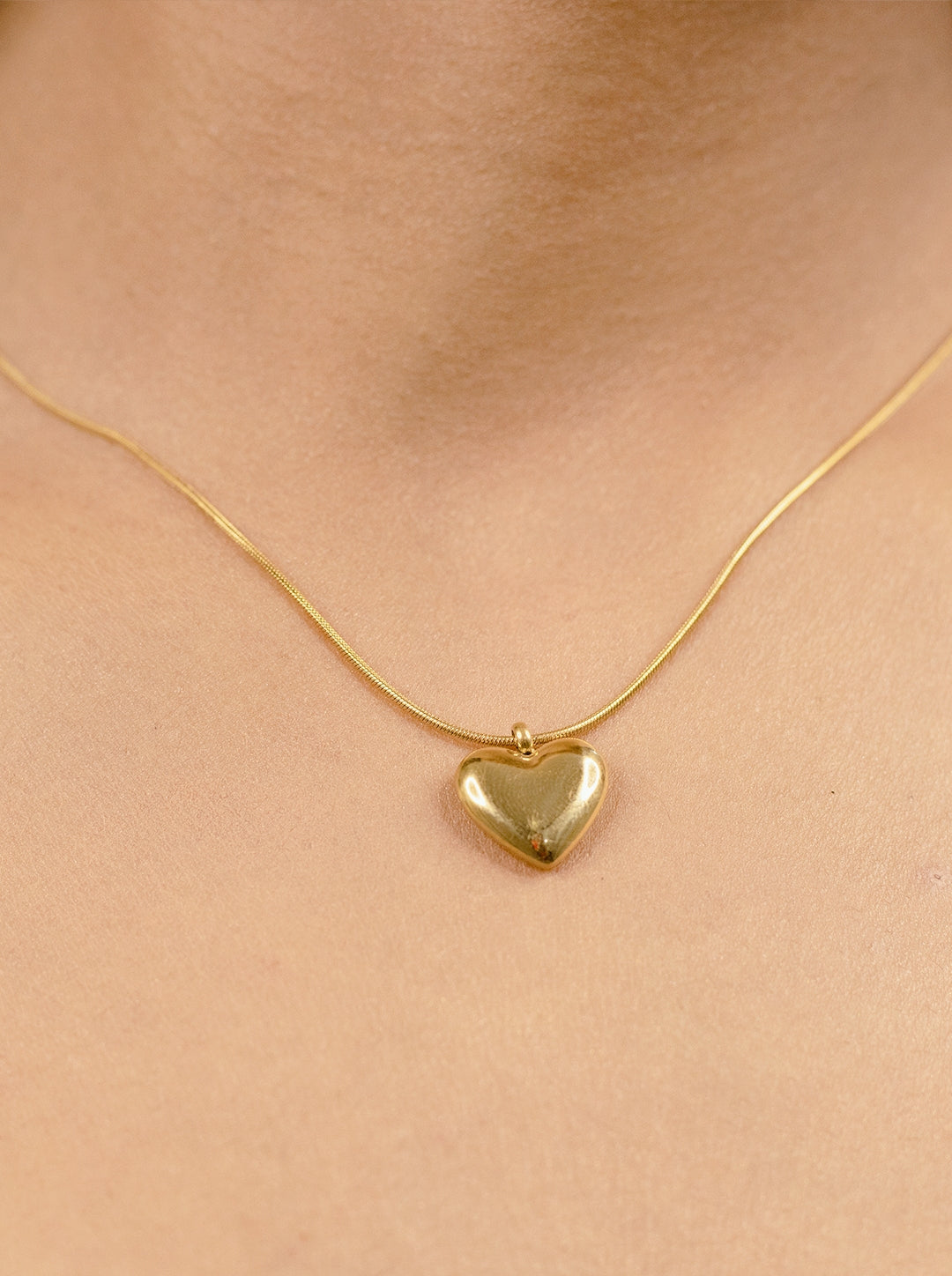 Minimalist gold heart pendant necklace on fine chain, elegant everyday jewelry for women.