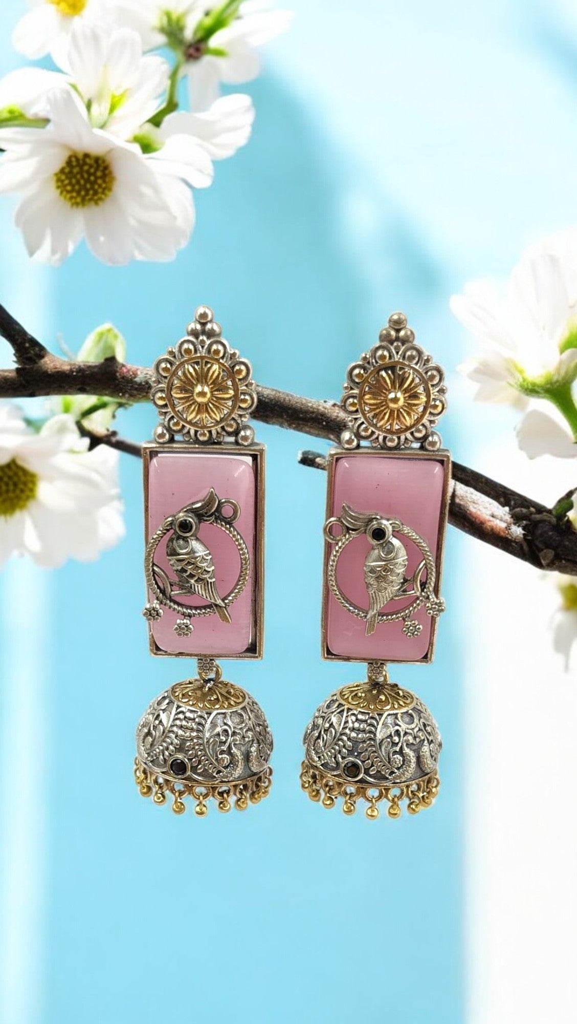 Graceful pastel pink jhumkas with intricate parrot motif – vintage charm with a modern twist.