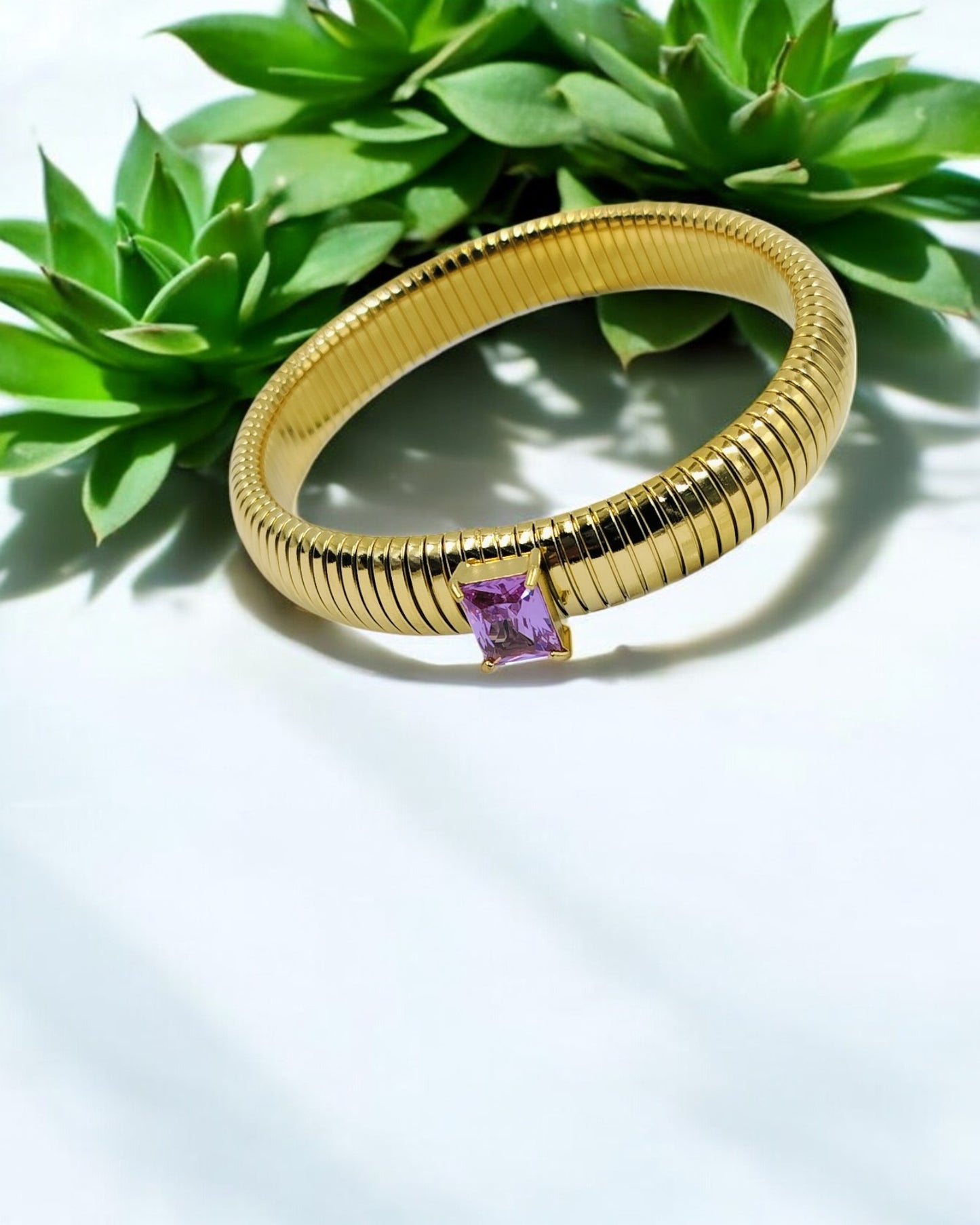 Elegant gold plated flexible bangle featuring a radiant purple emerald-cut stone – a chic fusion of sophistication and modern charm, perfect for any occasion.