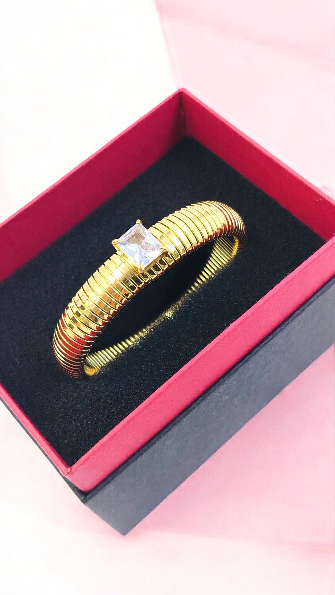 Elegant gold plated bangle with a radiant square-cut solitaire, a timeless statement piece for parties and special occasions.