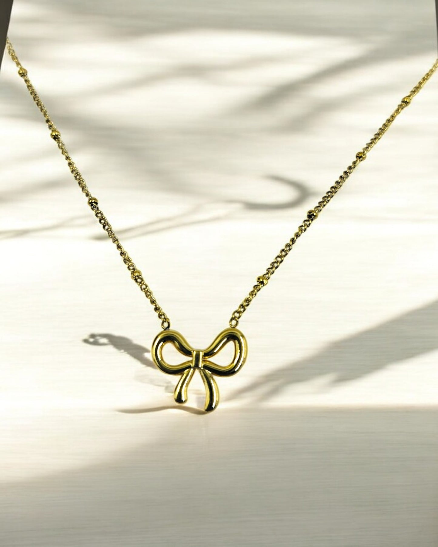 Elegant gold plated bow pendant necklace for women, minimalist lightweight jewelry perfect for casual and festive wear.