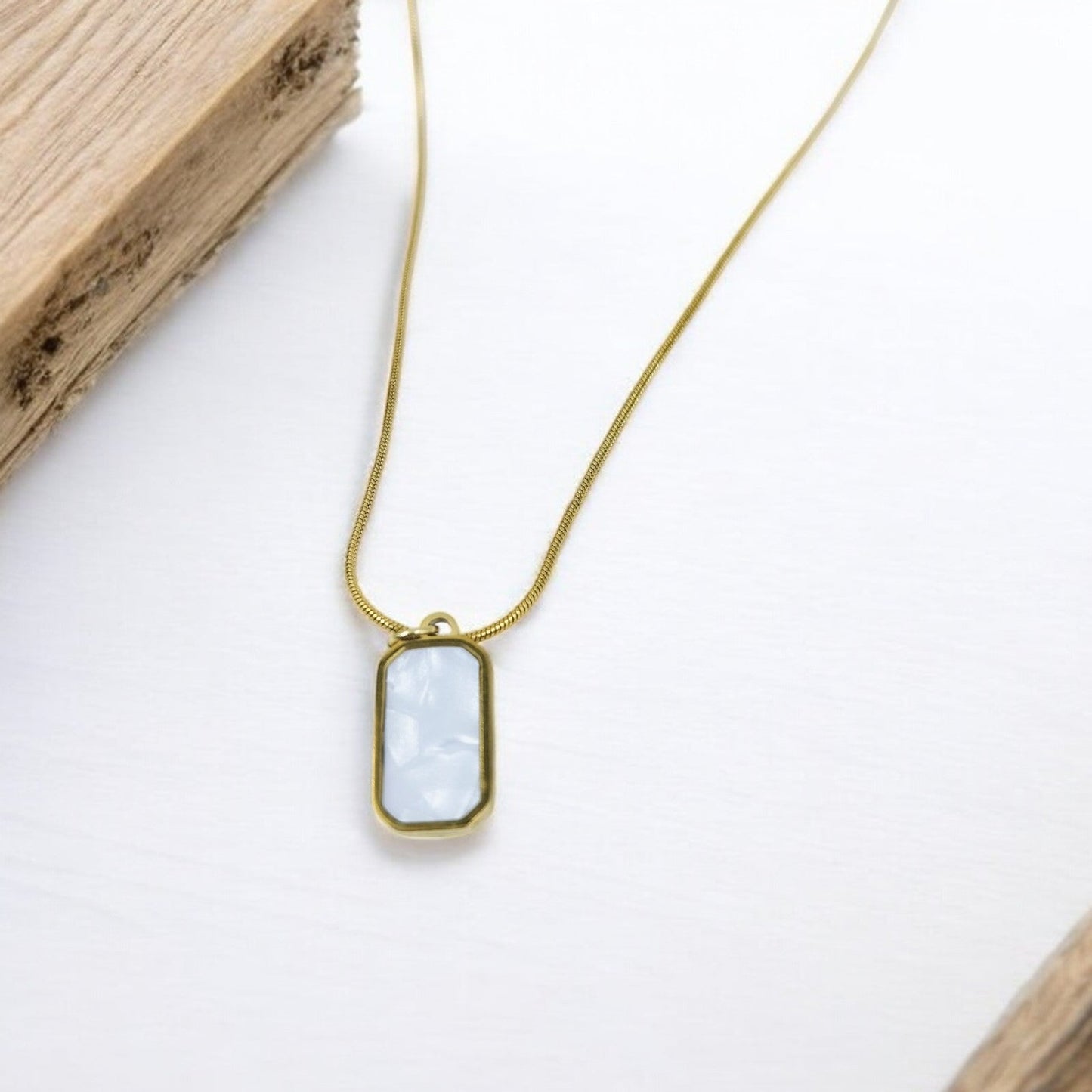 Minimalist gold chain necklace with rectangular white stone pendant, modern everyday jewelry for women.
