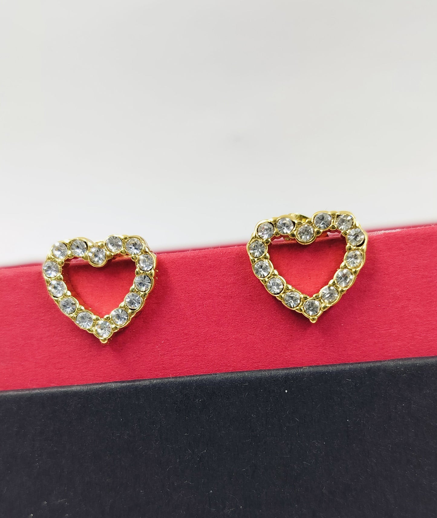 Gold open-heart stud earrings with sparkling crystals, offering a delicate and romantic accessory for daily wear or gifting.