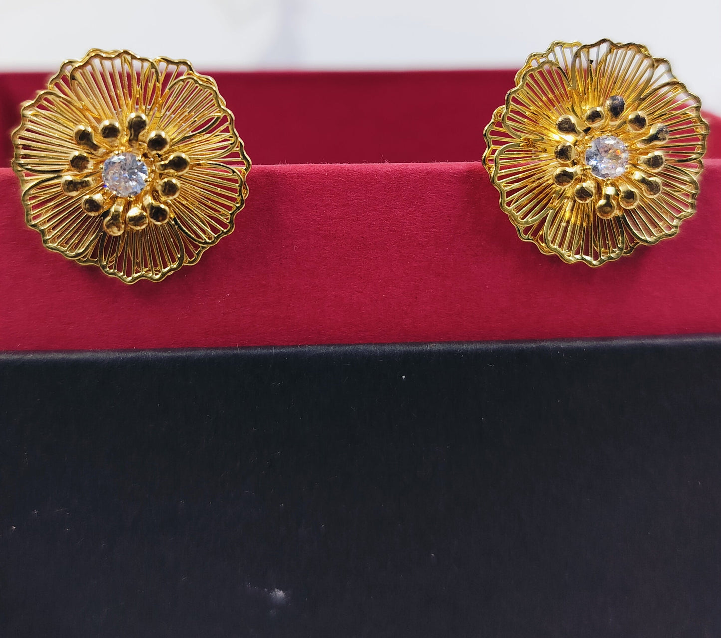 Gold floral stud earrings with intricate petal design and crystal centerpiece, perfect for festive and elegant looks.