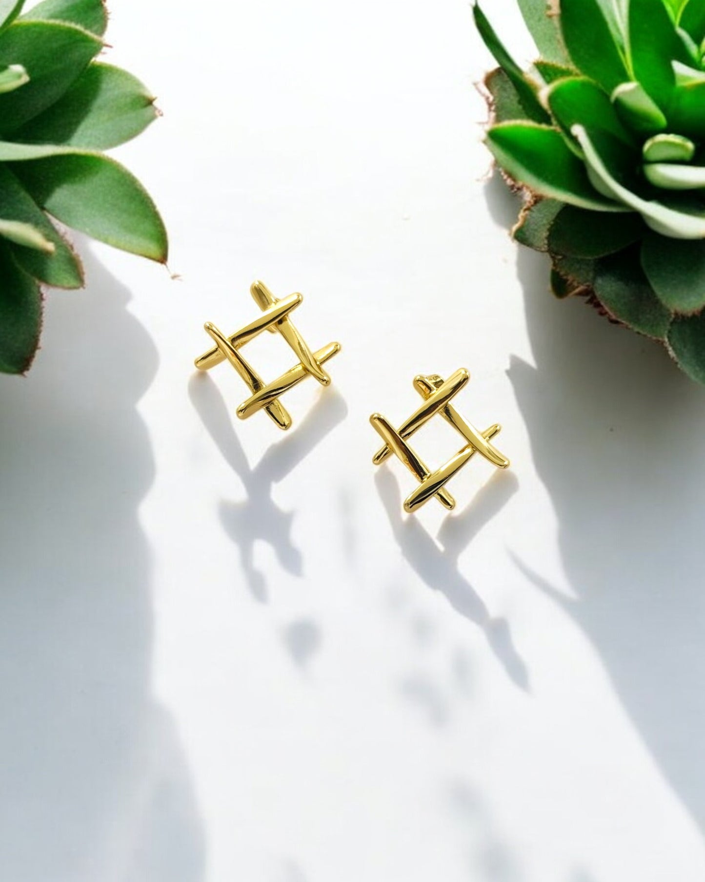 Minimalist gold geometric stud earrings with crisscross design, modern jewelry style for daily wear.