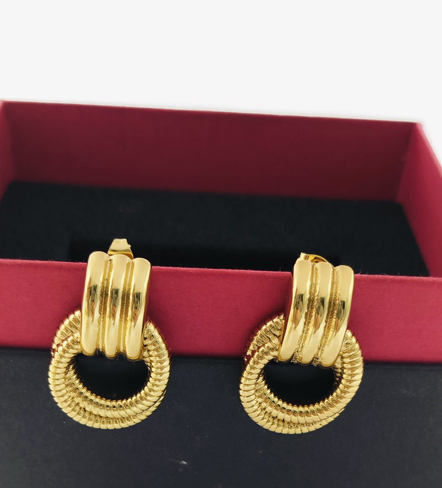 Chunky textured gold hoop earrings with layered loops displayed in a red and black box, bold statement jewellery design