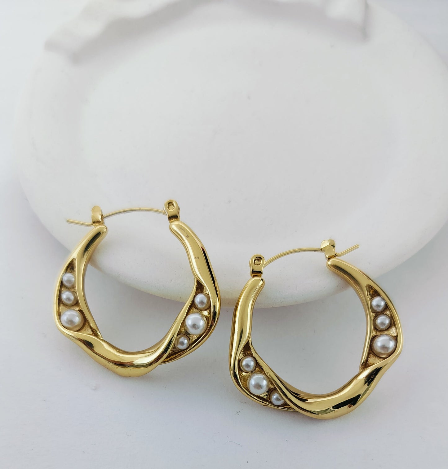 Stylish gold hoop earrings with delicate pearl details, designed to add elegance and timeless charm to any outfit.