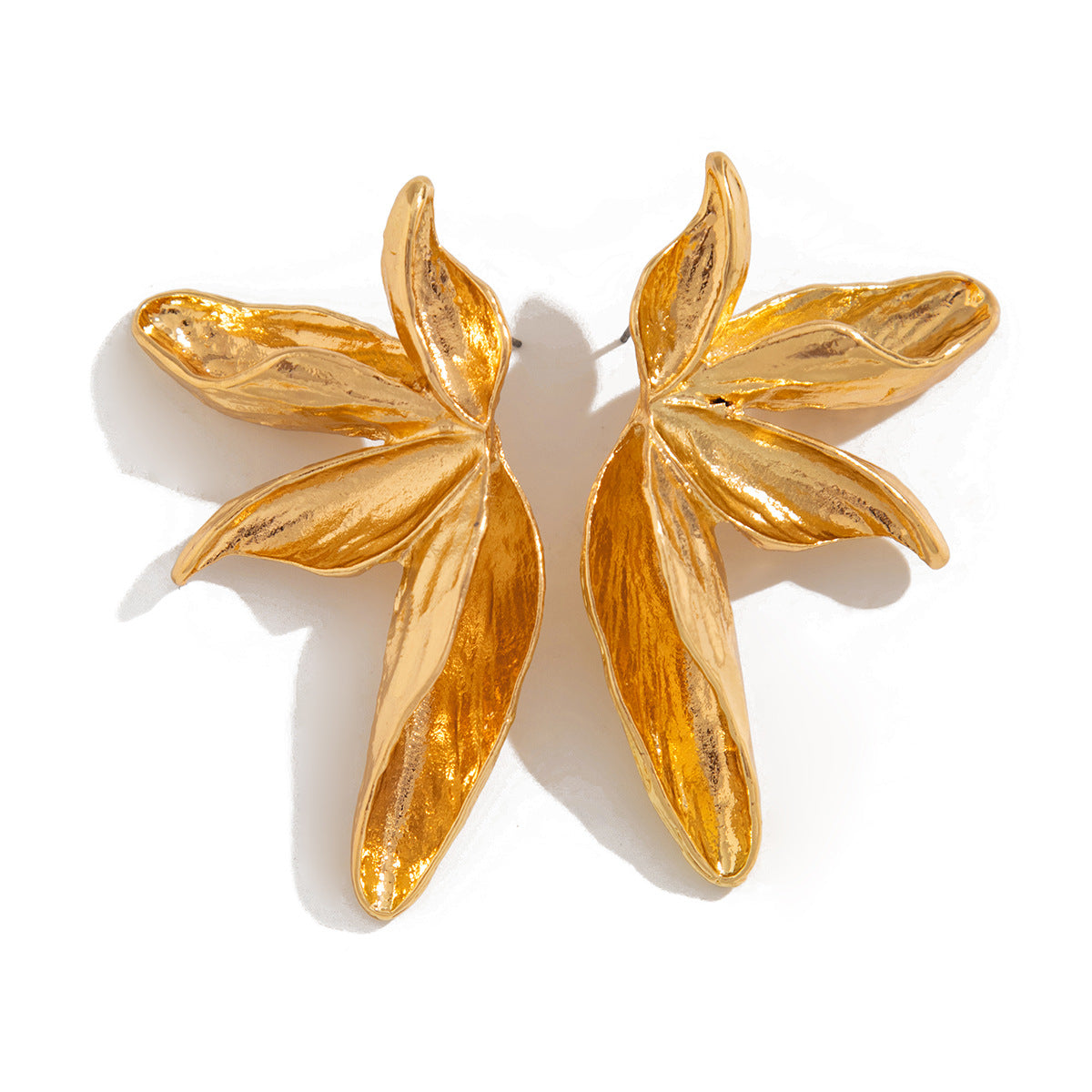 Gold leaf-shaped earrings on a white background