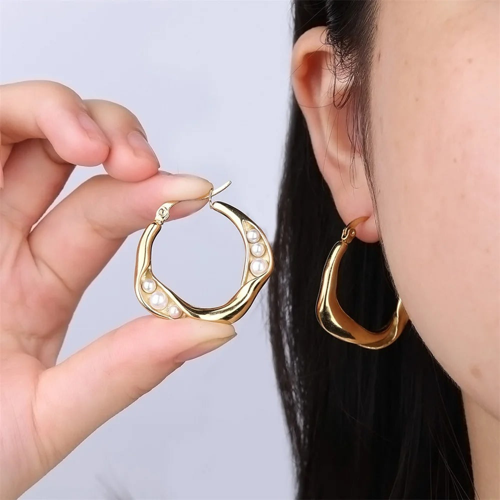 Stylish gold hoop earrings with pearl accents, designed to add timeless elegance and charm to any modern.