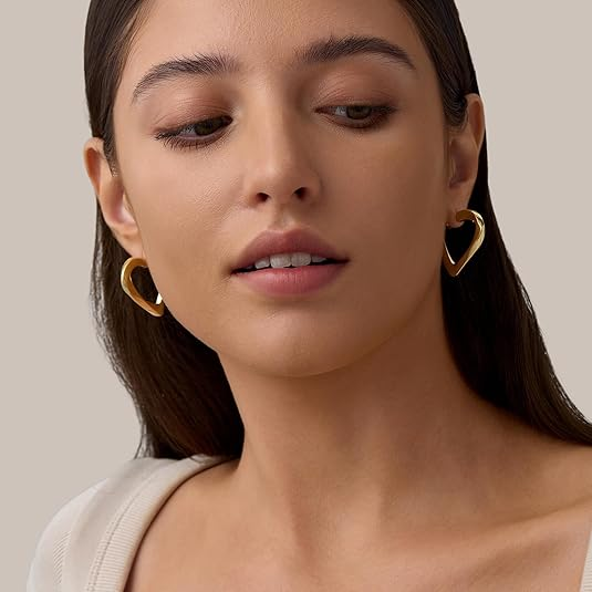 Young woman wearing stylish gold heart-shaped earrings, elegant lightweight jewelry for women’s daily and party wear.