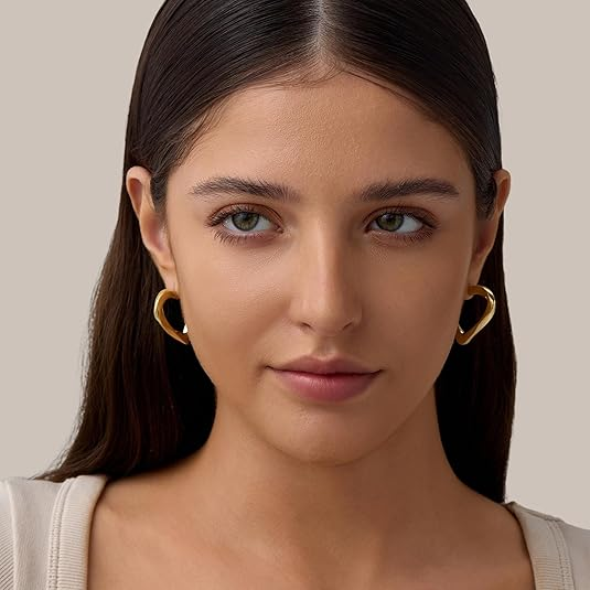 Beautiful woman wearing elegant gold heart-shaped earrings, trendy lightweight jewelry for women’s daily and party wear.