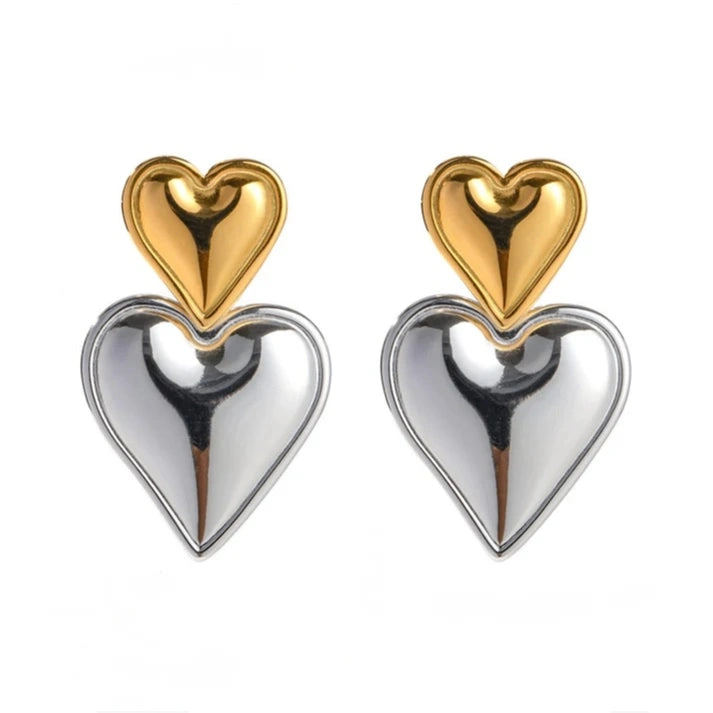 Dual-tone earrings featuring a gold heart stud with a silver puffy heart drop for a bold, trendy look.