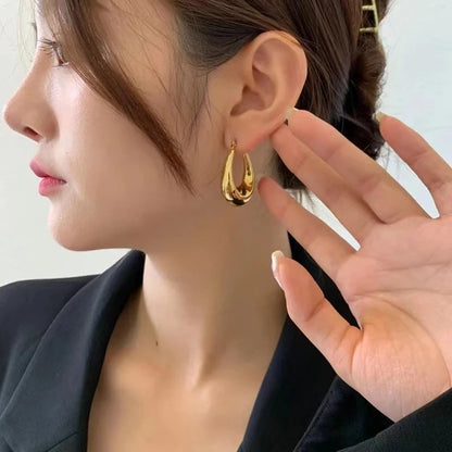 Elegant gold hoop earrings on model, modern women jewellery perfect for office wear, party style and gifting choice.