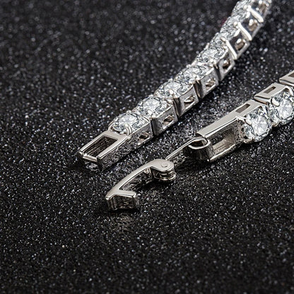 Close-up of a silver bracelet with clear stones on a dark textured background