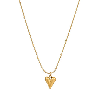 Minimalist gold necklace with heart-shaped pendant and beaded chain.