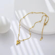 Stylish gold beaded chain necklace with heart pendant displayed on minimal white background.