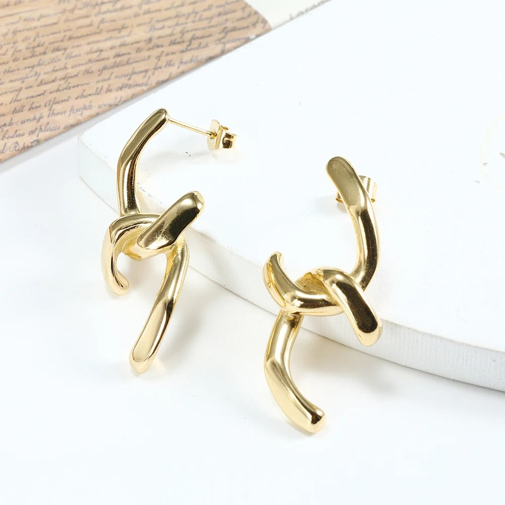 Gold abstract knot earrings with modern artistic design, stylish statement jewelry for women.