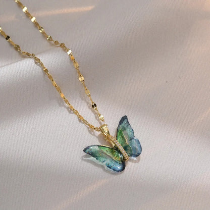 Butterfly-shaped pendant on a gold chain against a light background