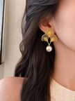 Model wearing a gold ginkgo fan pearl drop earring showing scale and fit on ear
