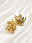 Side-angled close-up of gold butterfly stud earrings showing three-dimensional wing detail