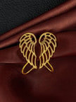 Pair of gold-plated angel wing ear cuffs laid flat facing each other on burgundy satin fabric