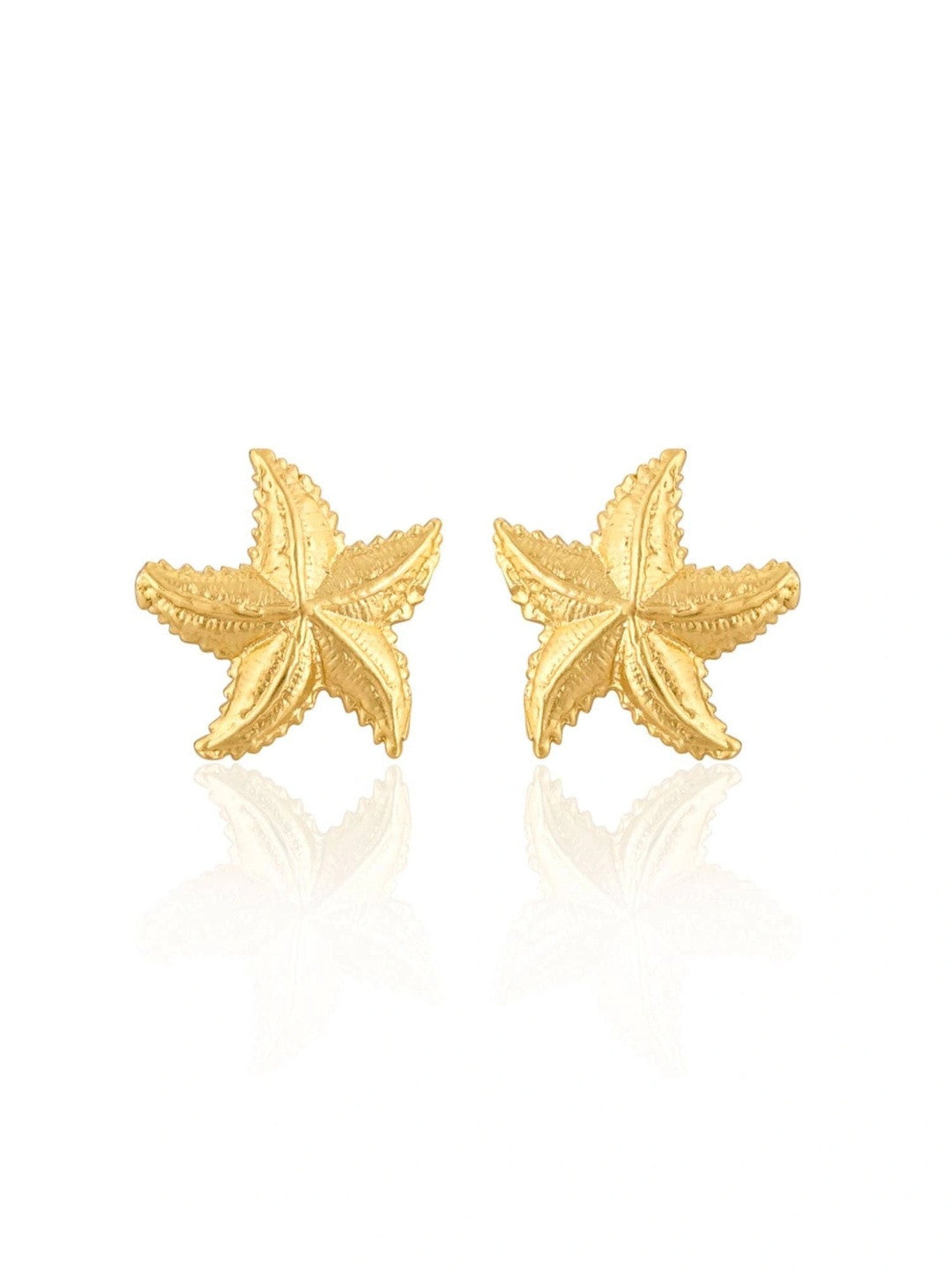 Pair of gold-plated starfish stud earrings isolated on white background with subtle reflection below