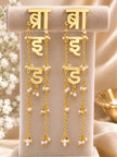 Pair of gold-plated Hindi script bride earrings displayed upright on a beige jewellery stand with pearl bead chain tassels