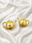 Back view of one gold teapot earring showing push-back stud fitting alongside front-facing earring on white surface