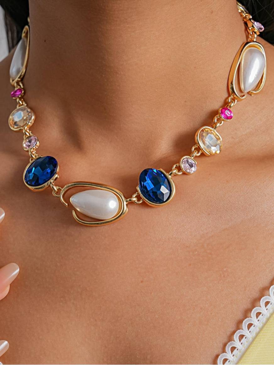 Close-up of pearl and blue crystal necklace worn on a model in a yellow top