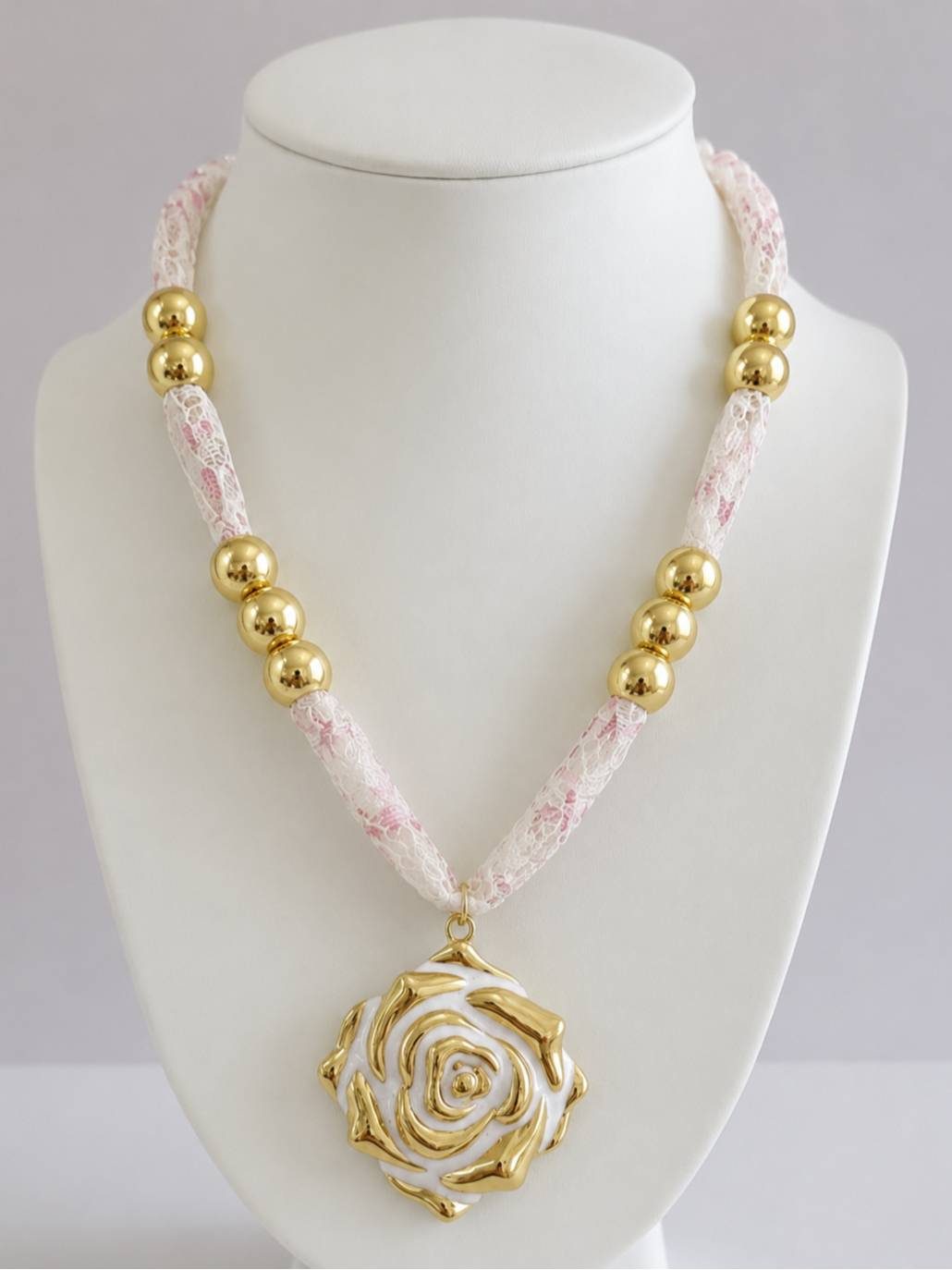 Gold-plated rose enamel pendant necklace displayed on a white jewellery bust