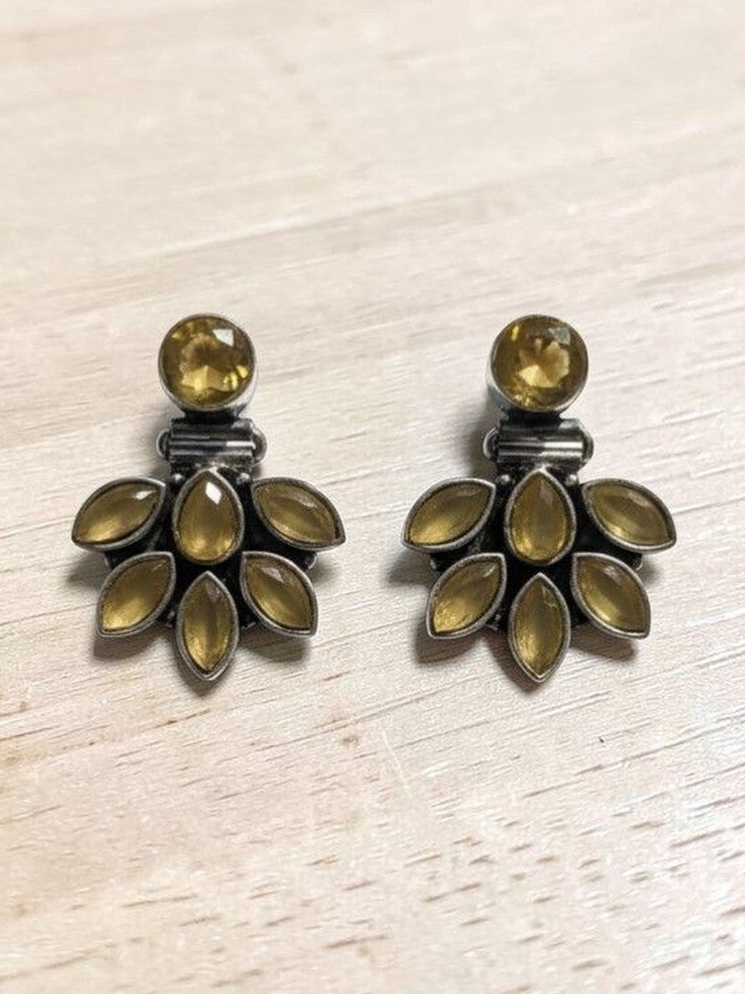 Oxidised silver citrine ear jacket earrings laid flat on a light wooden surface showing full fan detail