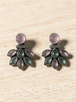 Close-up of oxidised silver floral earrings showing marquise pink and green stone petal arrangement on wood surface