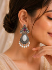 Side profile of woman wearing oxidised silver elephant chandbali earring with pearl fringe against light background