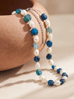 Blue agate and pearl beaded necklace draped over a terracotta pot showing bead detail and silver clasp