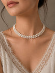 Model wearing two-row pearl crystal choker necklace with white lace neckline bridal top