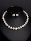 White faux pearl choker necklace displayed on a black bust with matching round pearl stud earrings
