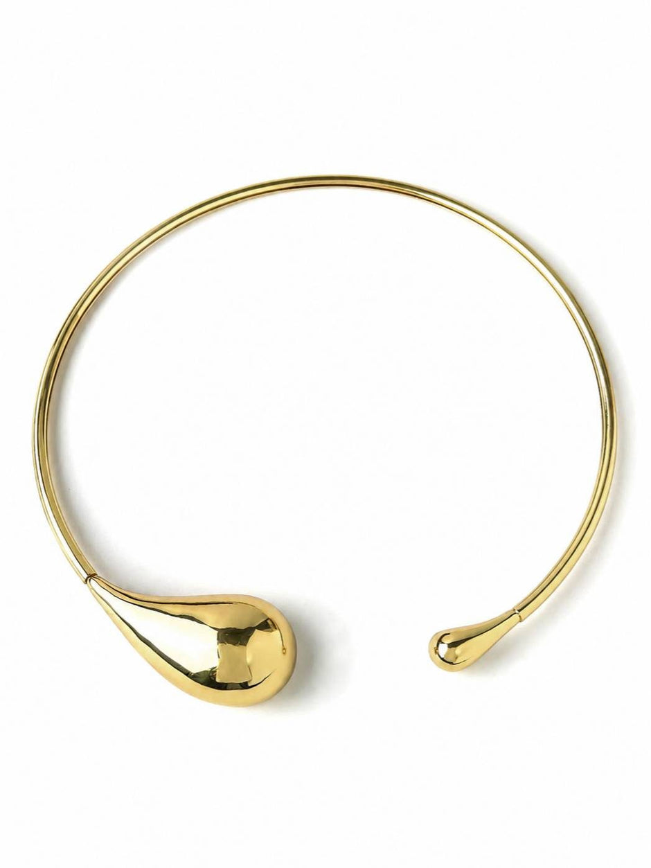 Gold-toned asymmetric teardrop torque choker necklace laid flat on white background