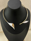 Gold-plated calla lily collar choker necklace displayed on a black jewellery bust, showing white enamel bloom and leaf detail