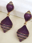Side-by-side detail shot of purple CZ shell-shaped drop earrings showing gold banding and stone texture