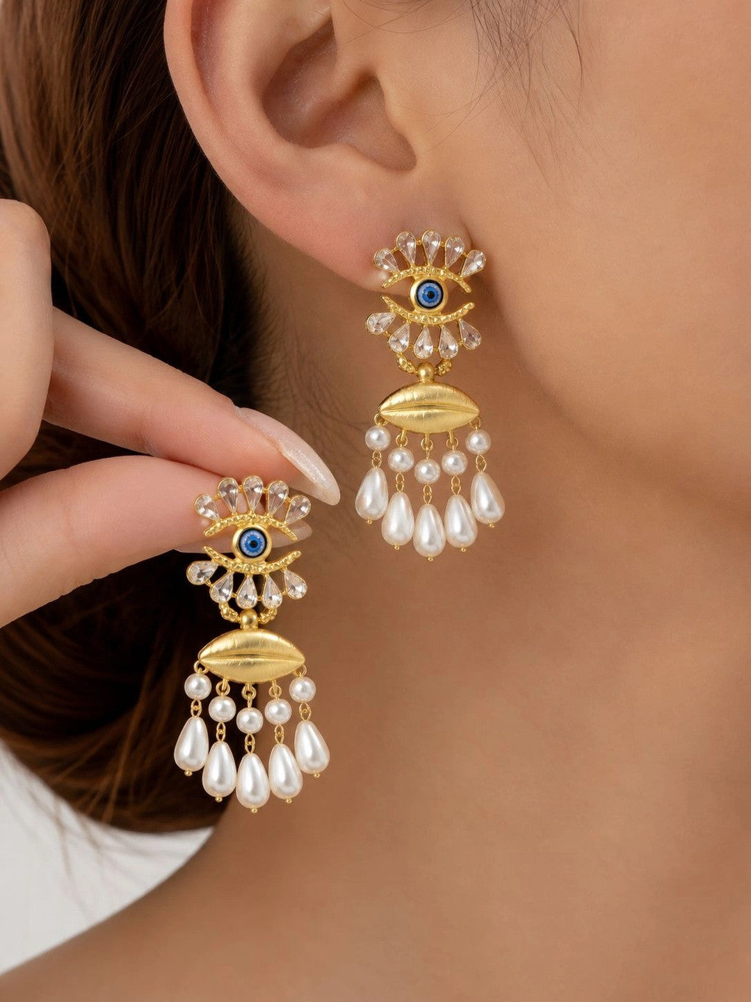 Model wearing gold evil eye pearl drop earrings showing full length and scale on ear