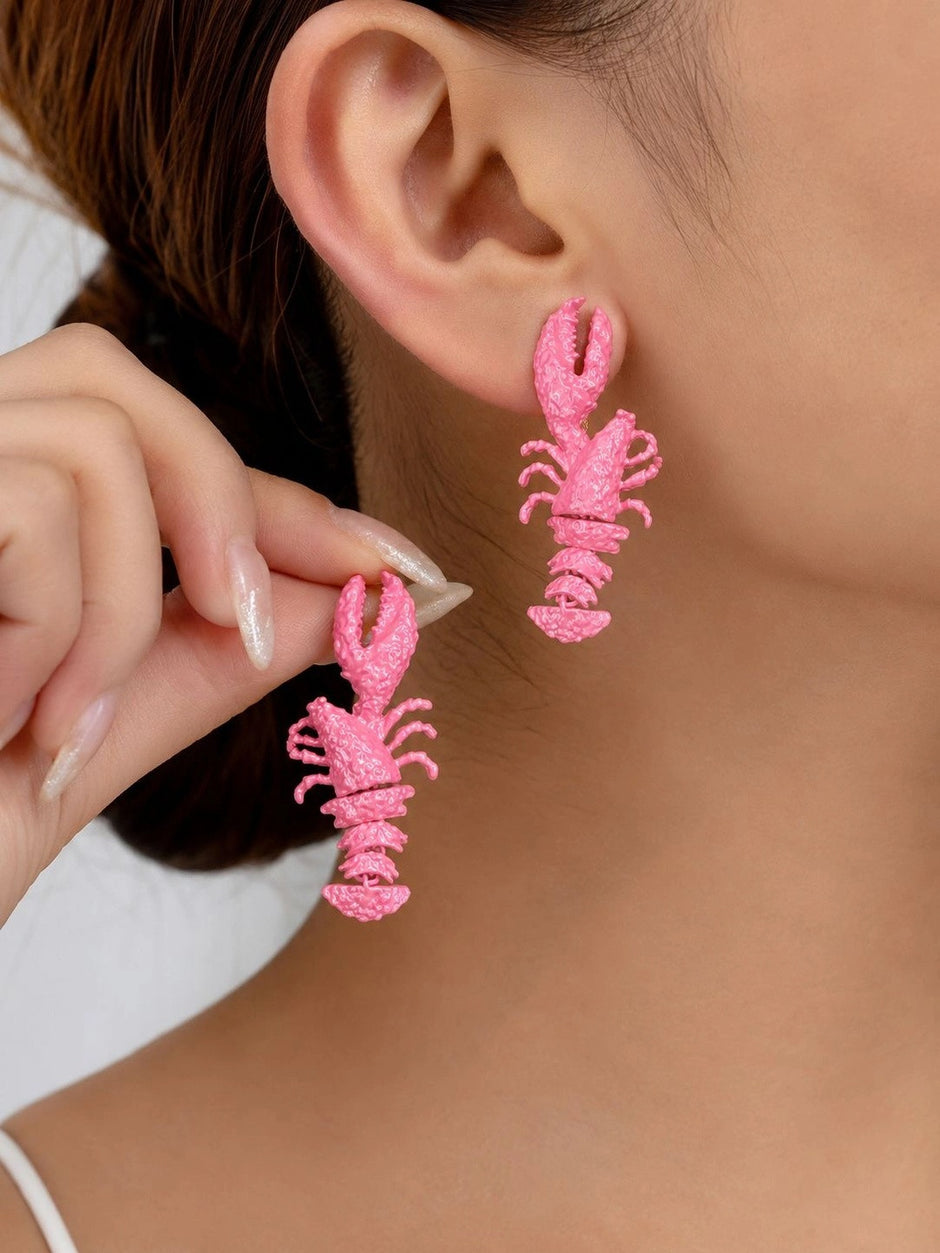 Model wearing pink lobster drop earrings on both ears, close-up side view