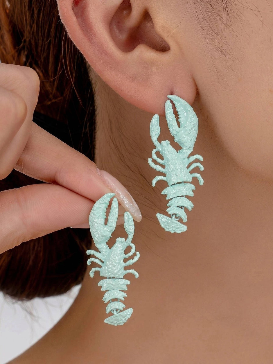 Close-up of mint blue lobster drop earrings being worn on a womans ear showing full dangling length